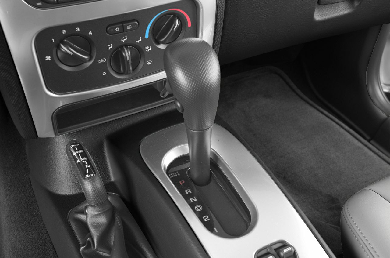 Automatic gear shift lever, manual 4WD selector, and climate control knobs in a vehicle interior