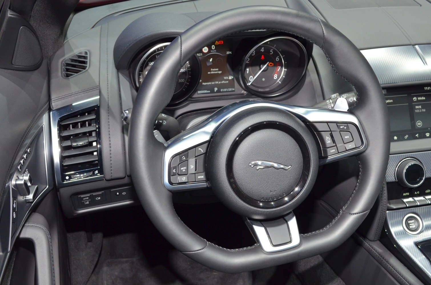 Steering wheel with controls and dashboard gauges in car interior
