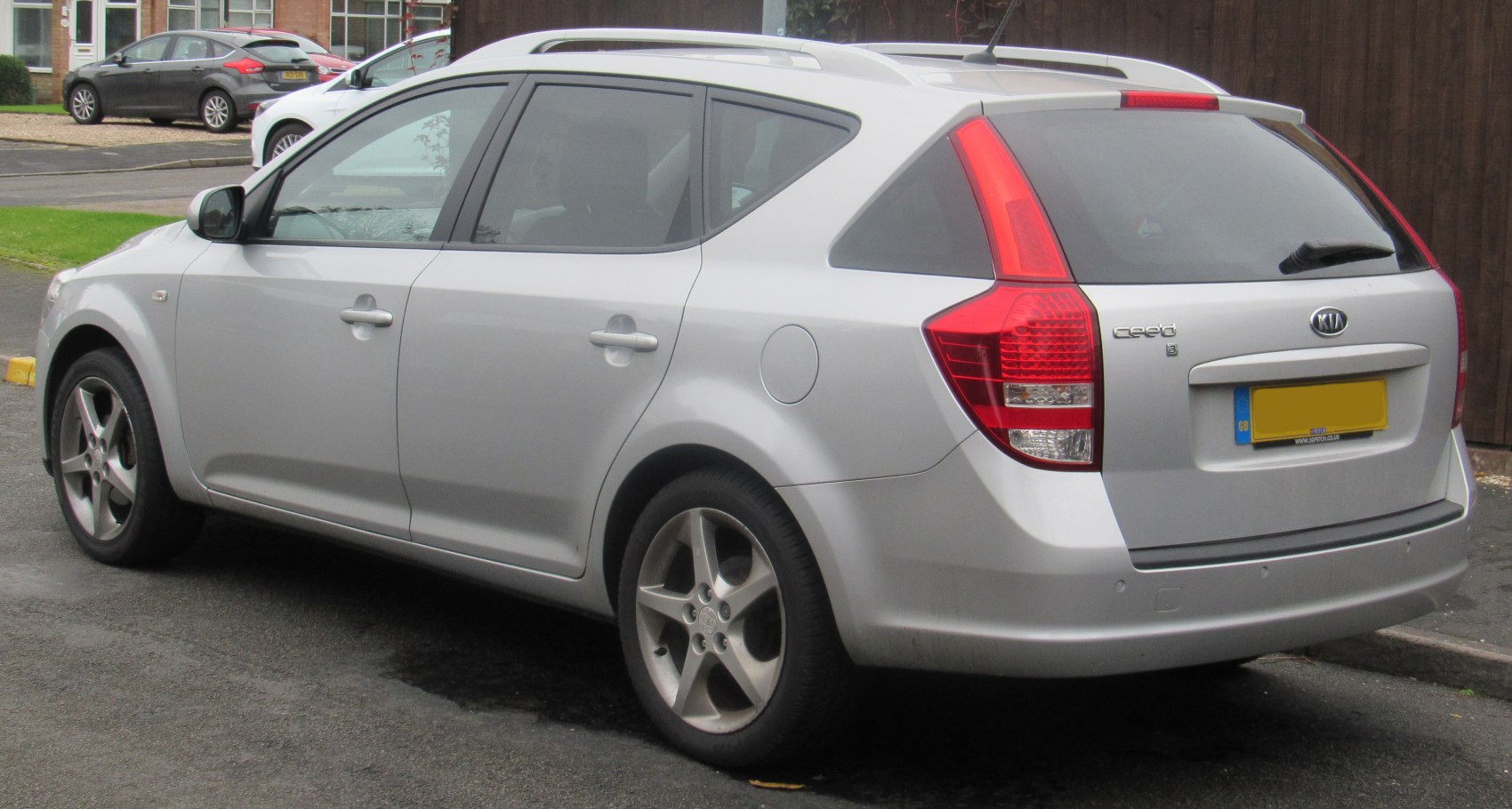 Rear and side view of silver station wagon with distinctive tail lights and alloy wheels