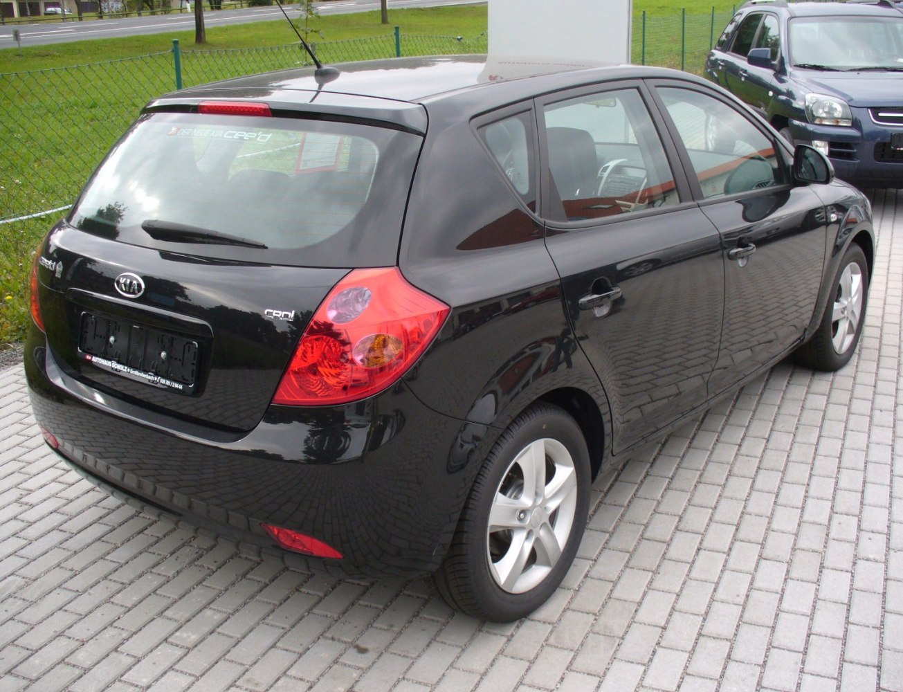 Black hatchback rear-side view with distinct taillights and alloy wheels