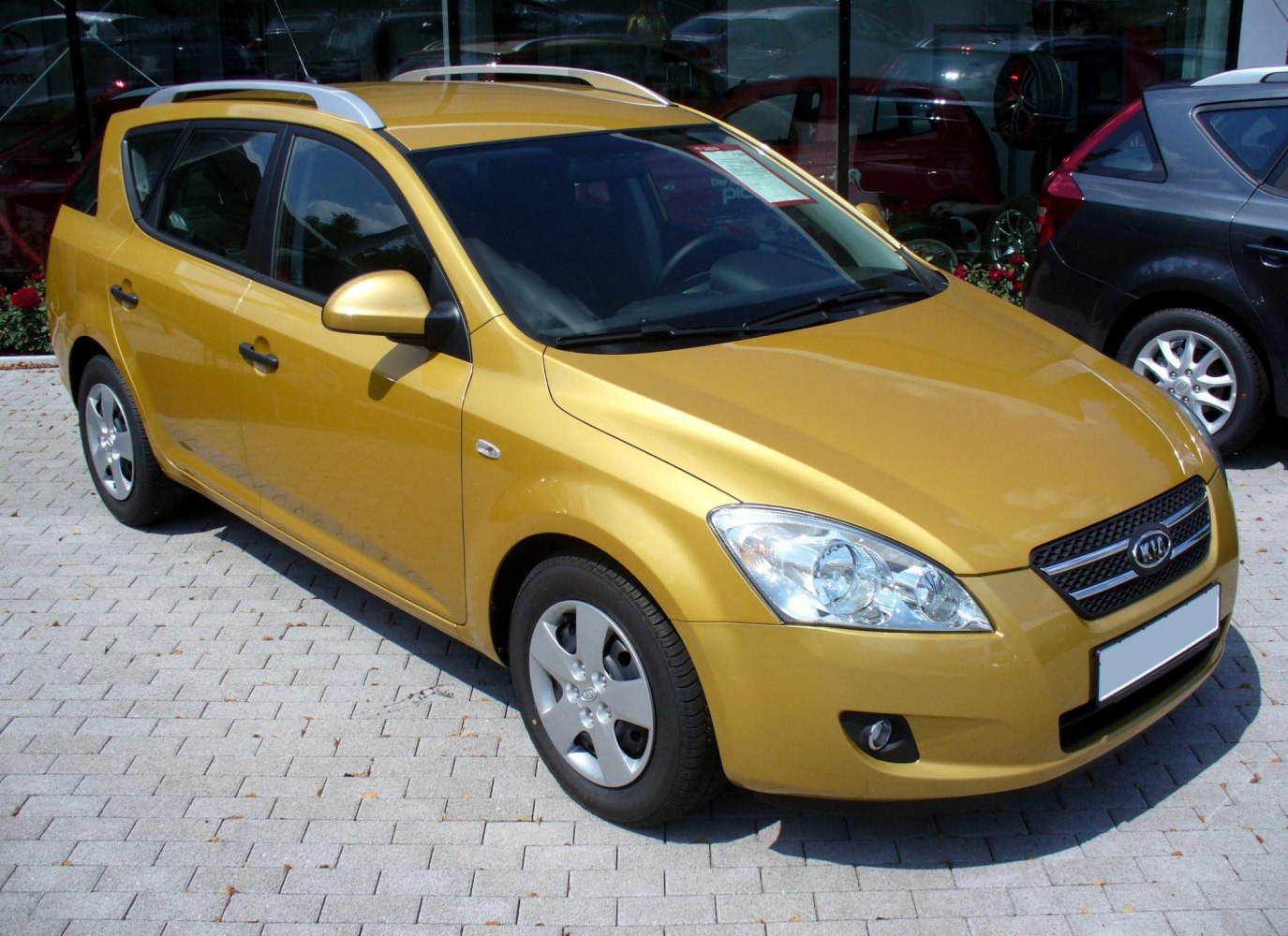 Front three-quarter view of metallic yellow compact wagon with roof rails