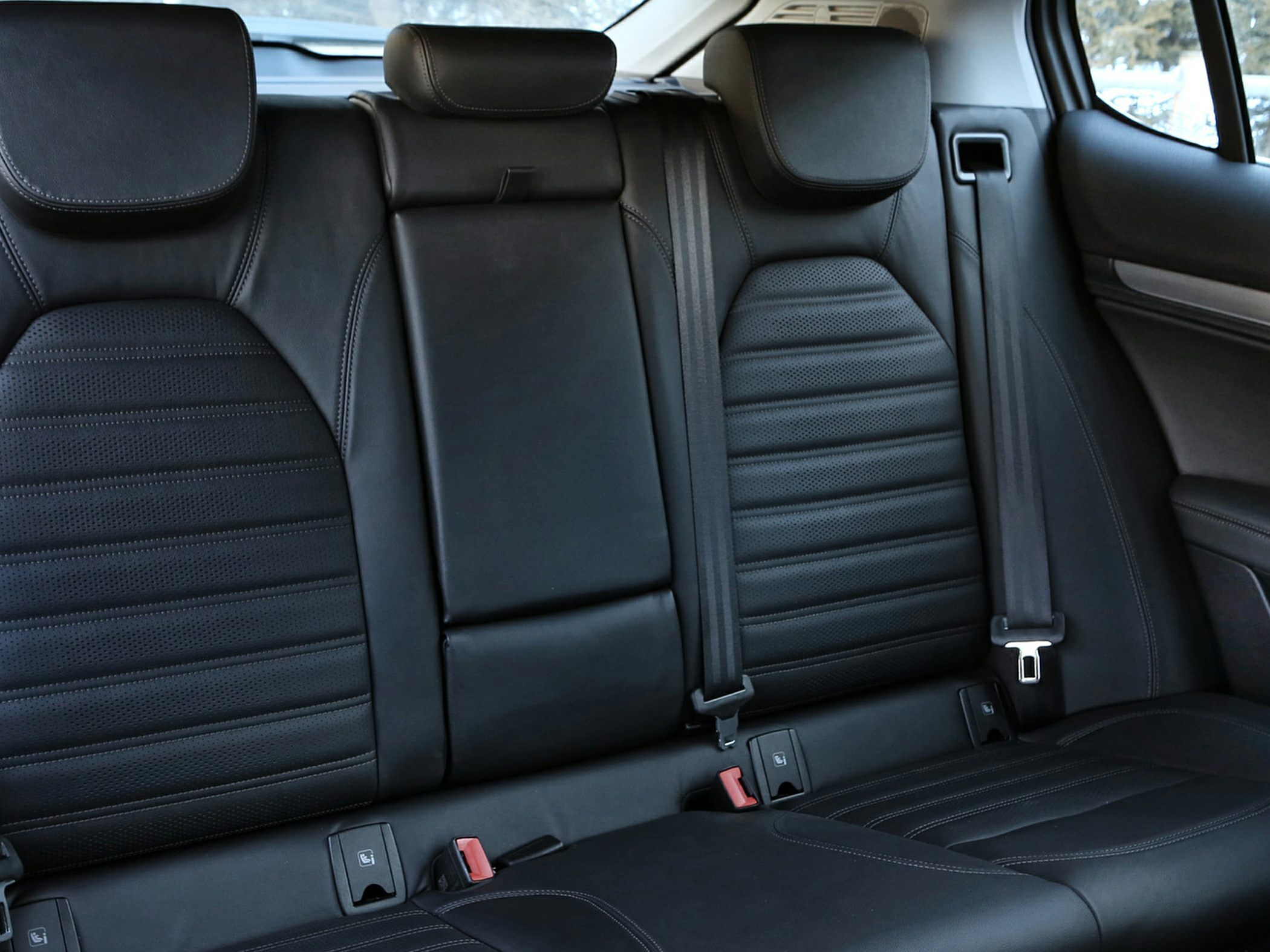 Black leather rear passenger seats with headrests and seat belts
