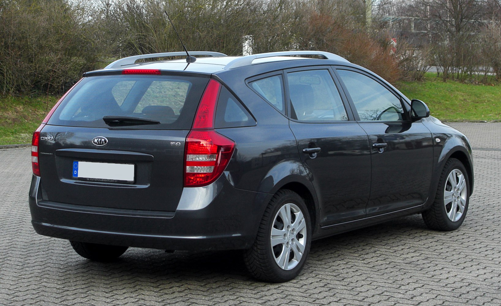Rear side view of a station wagon with distinct taillights and roof rails
