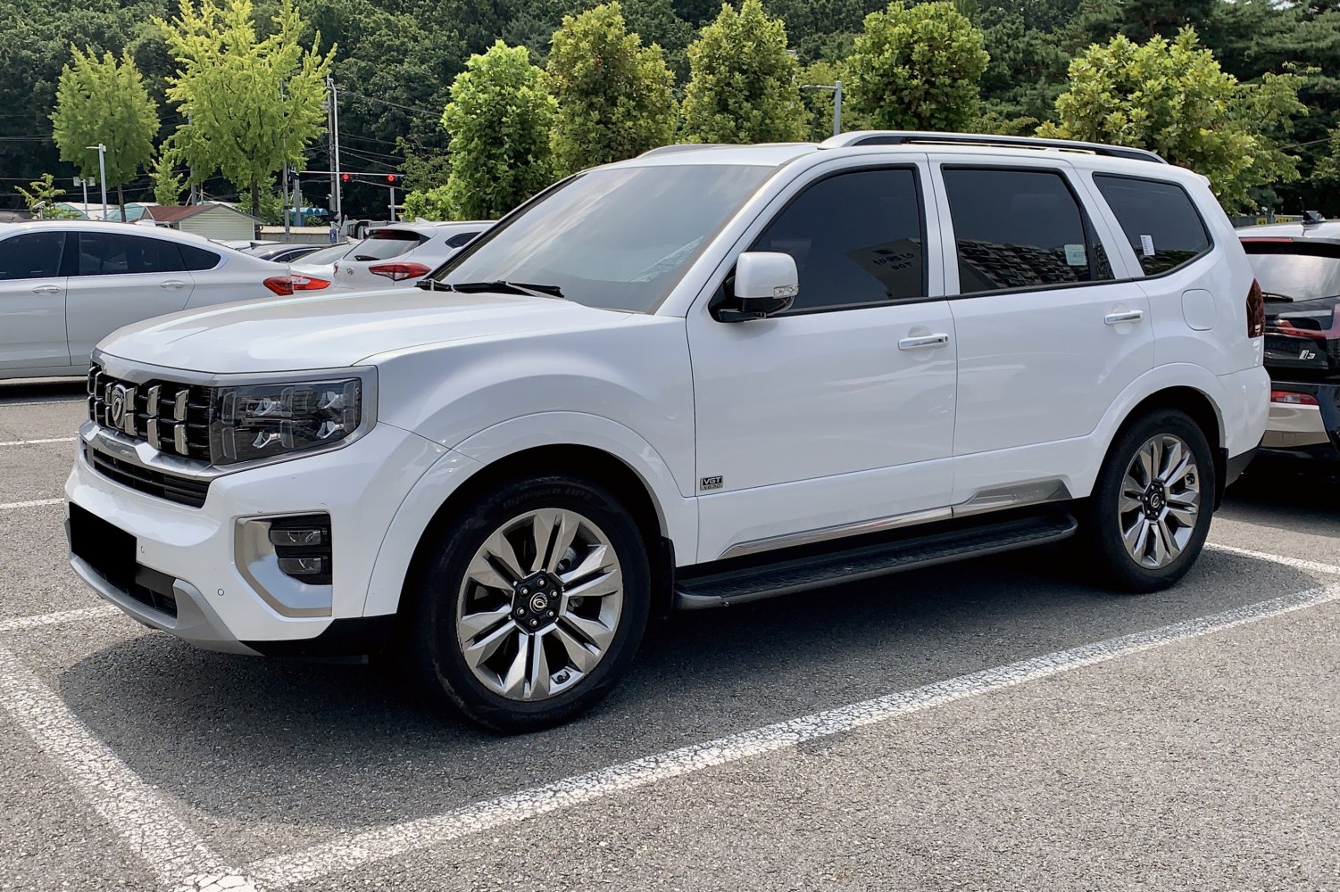 White SUV with modern grille, multi-spoke alloy wheels, and tinted windows side profile