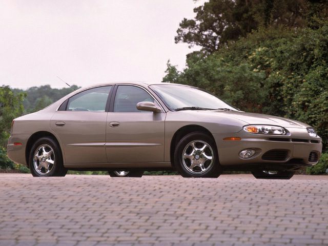 Side profile of sedan with chrome wheels on paved surface