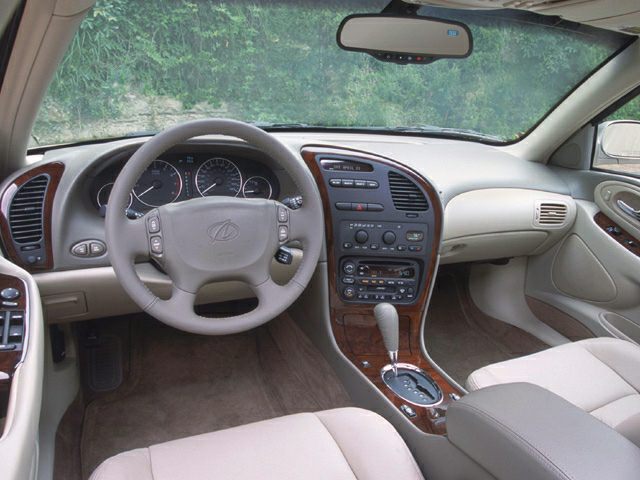 Classic dashboard layout with wood trim and beige leather seats