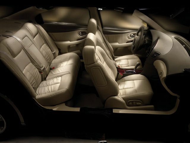 Beige leather front and rear seats with spacious car interior layout