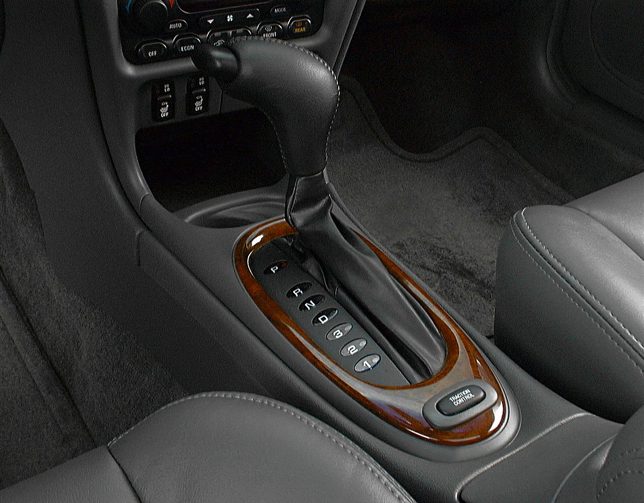 Automatic gear shift with traction control button and wood trim on car center console