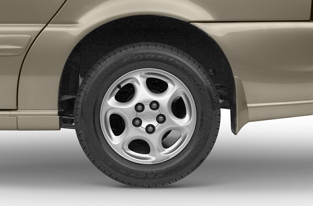 Alloy wheel with five rounded spokes and tire on vehicle rear side.