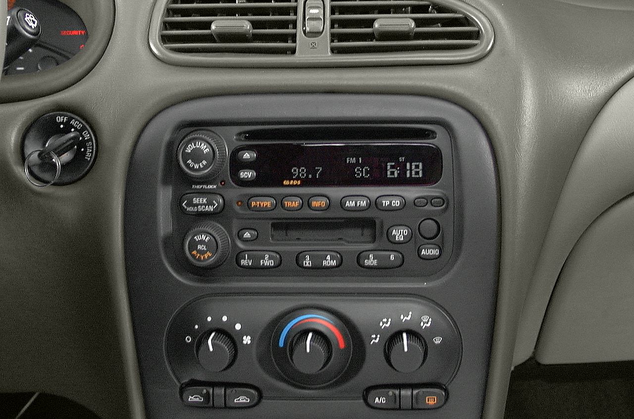 Radio and climate control panel with analog knobs and digital display
