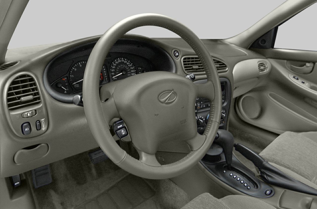 Dashboard and steering wheel with instrument cluster and controls in beige interior