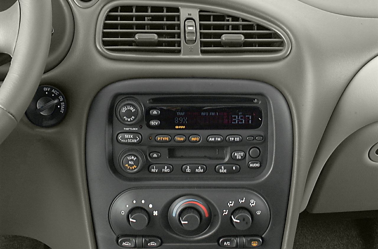 Dashboard radio and climate control dials with air vents.