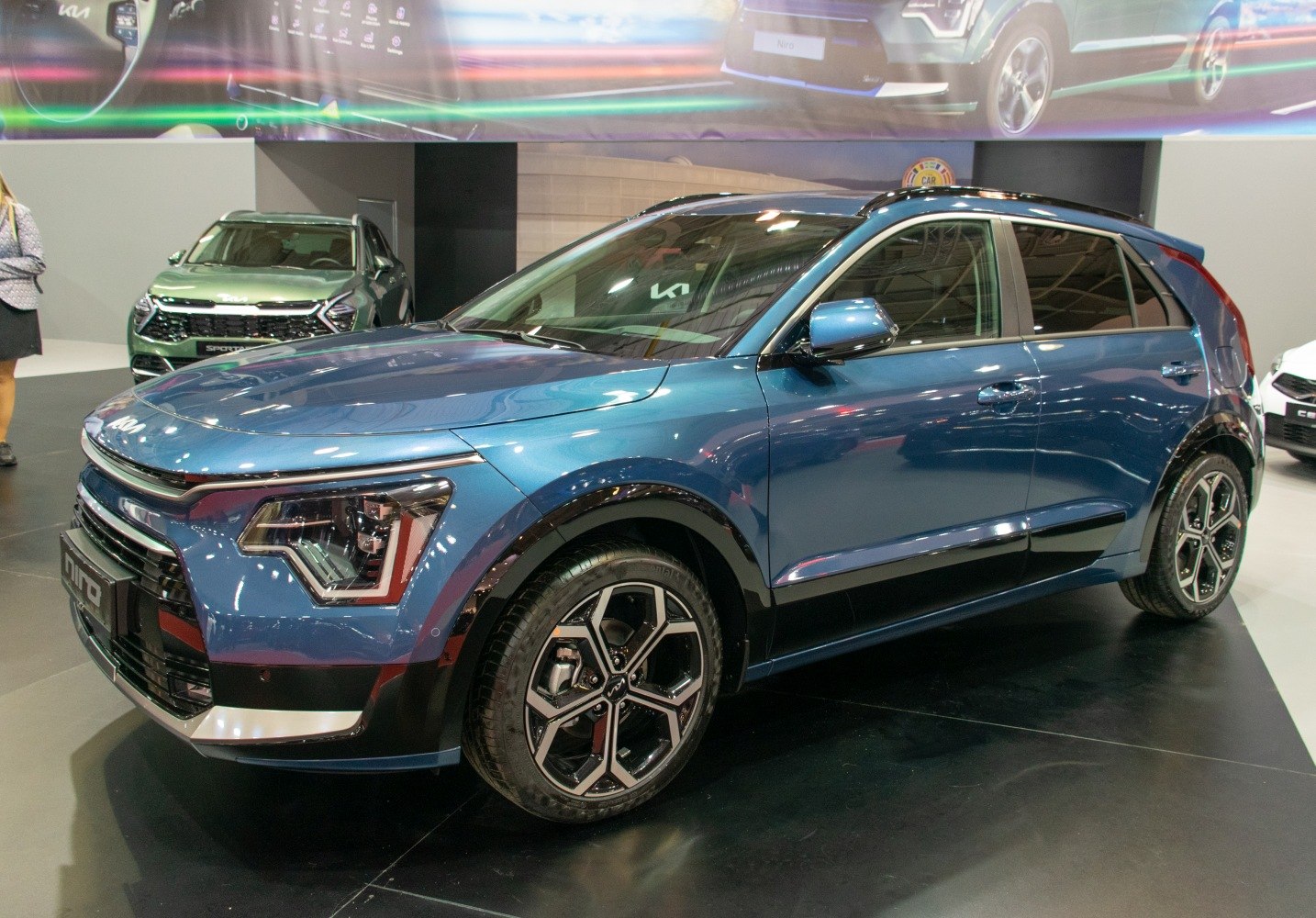 Front side view of a blue SUV with distinctive LED headlights and sporty wheel design.
