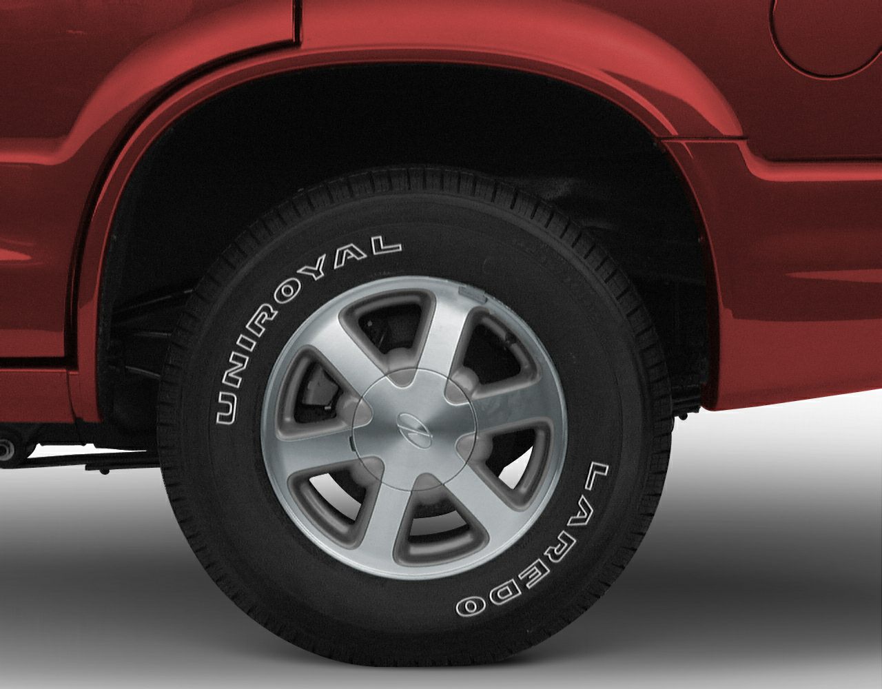 Alloy wheel with UniRoyal Laredo tire on red vehicle wheel arch