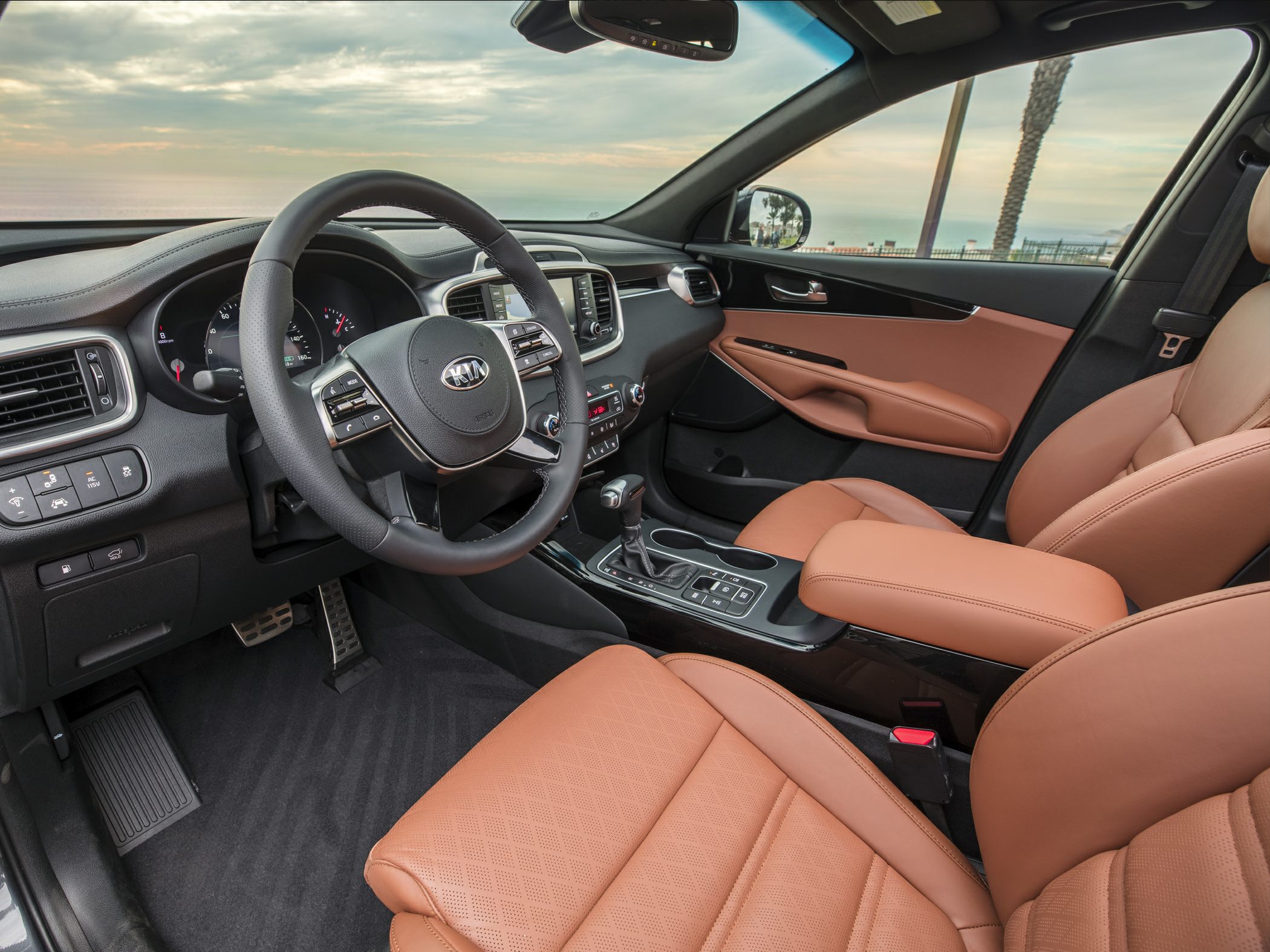Modern steering wheel with tan leather seating and dashboard controls