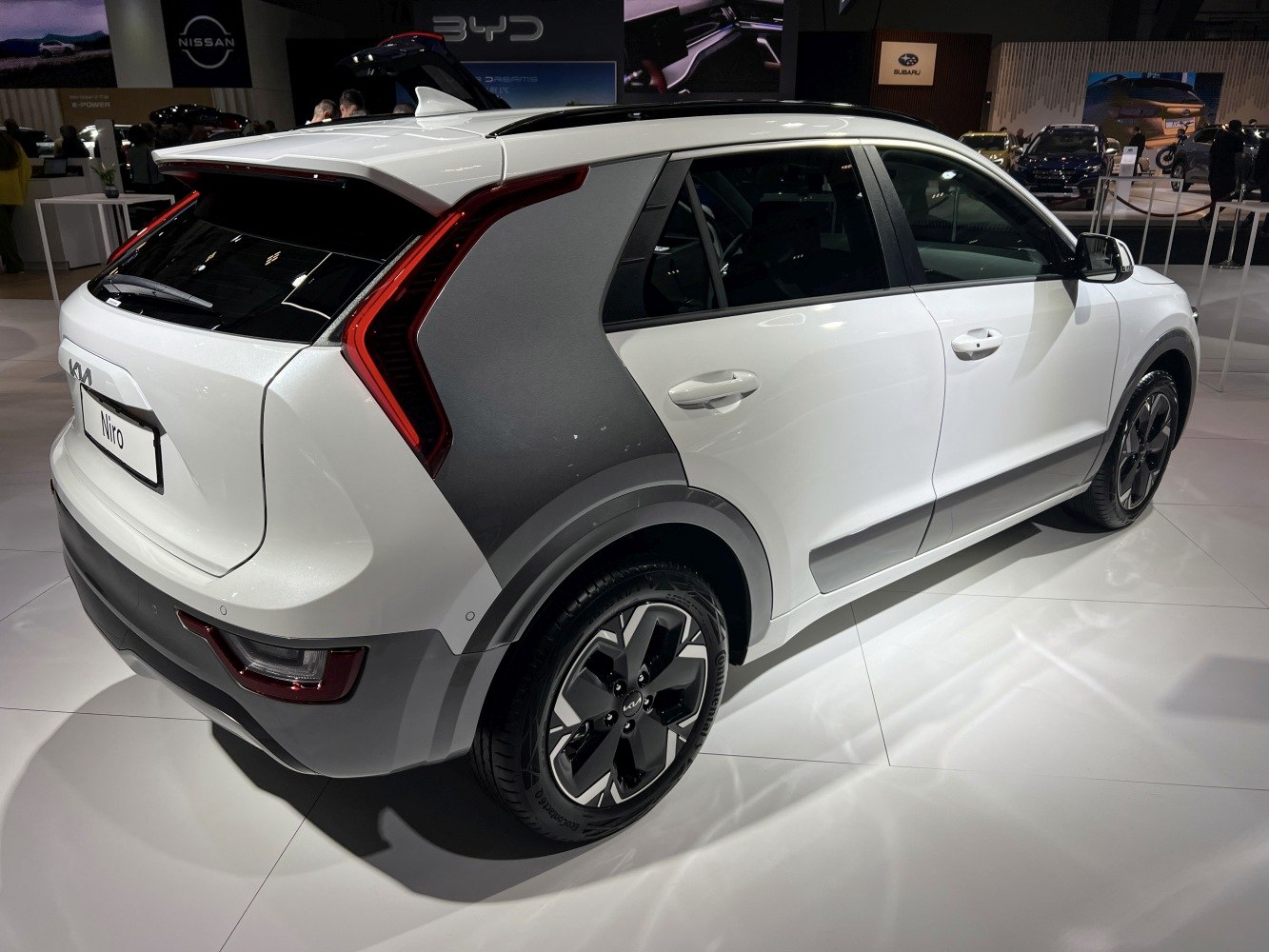 Rear side view with unique L-shaped tail light and aerodynamic design.