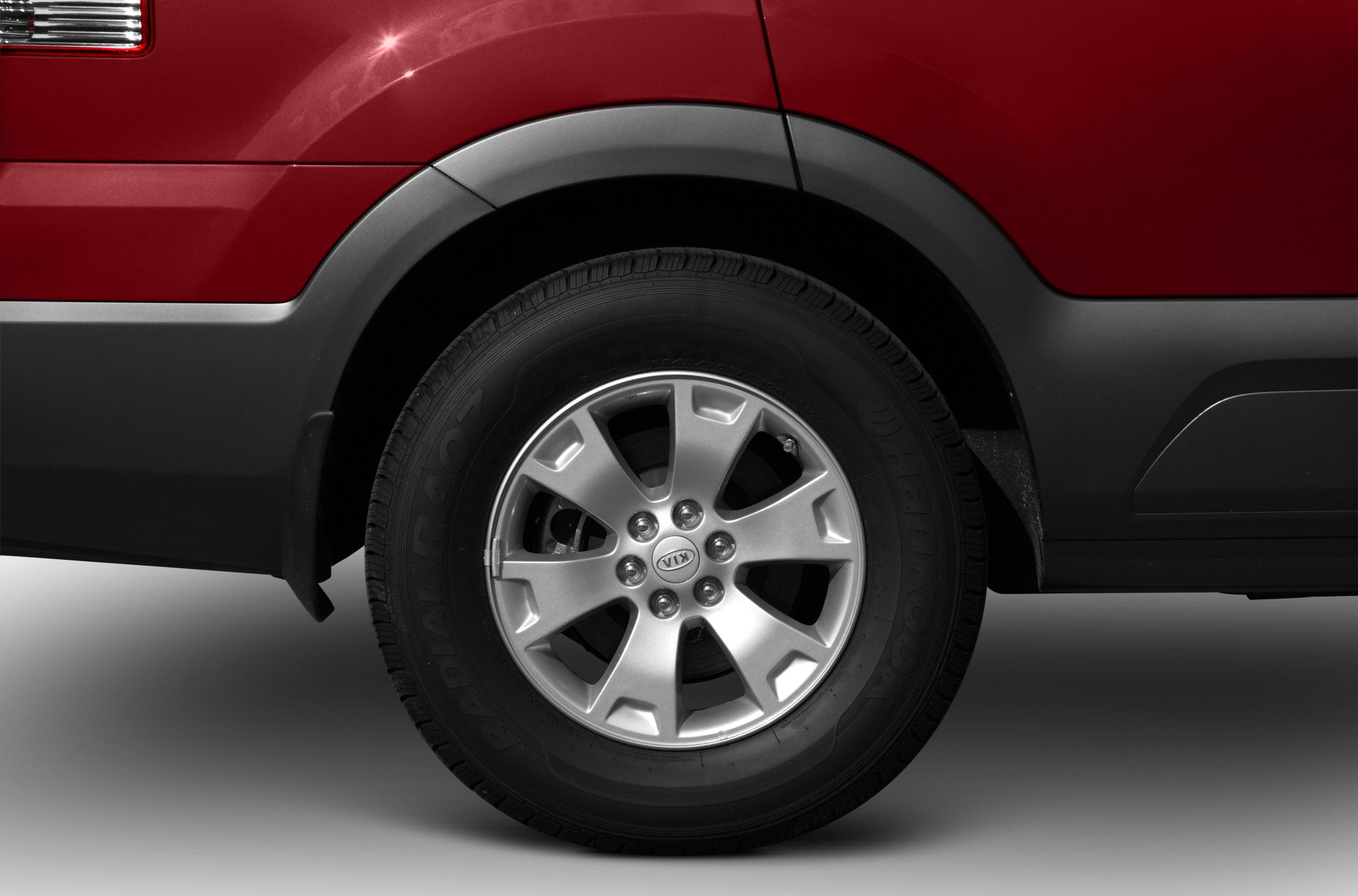 Alloy wheel with black plastic wheel arch and red car body