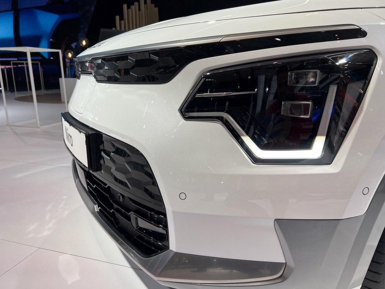 Close-up of front grille and LED headlight with geometric design