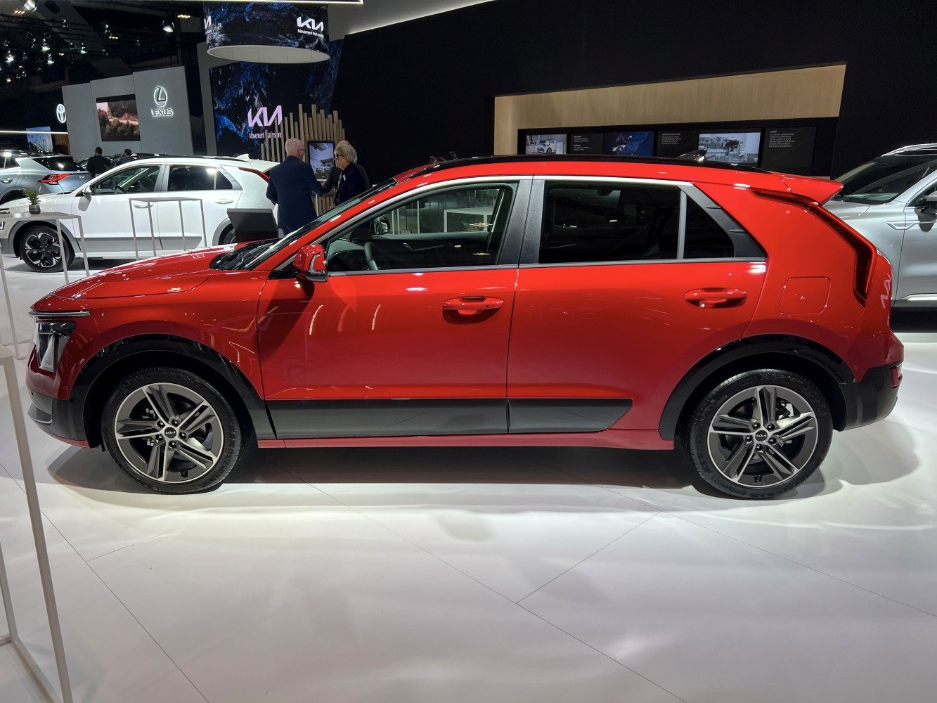 Side profile of a red modern crossover with alloy wheels.