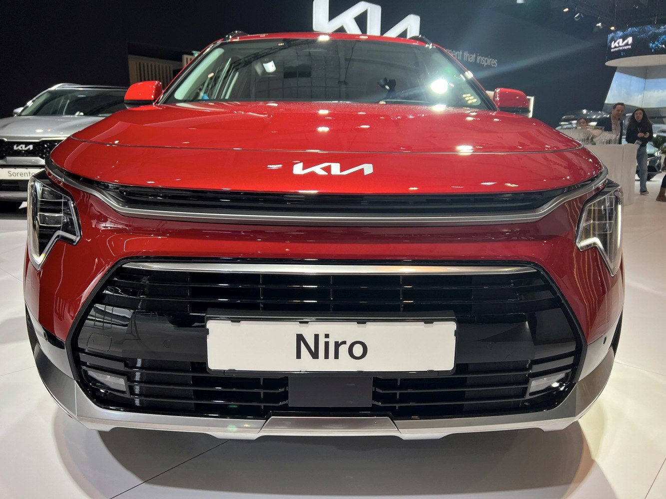 Close-up on distinctive front grille and LED headlights in a bright red vehicle