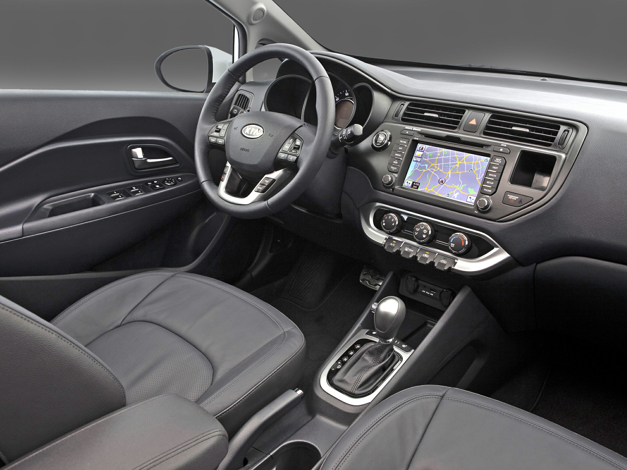 Steering wheel with controls and dashboard including navigation screen and climate control