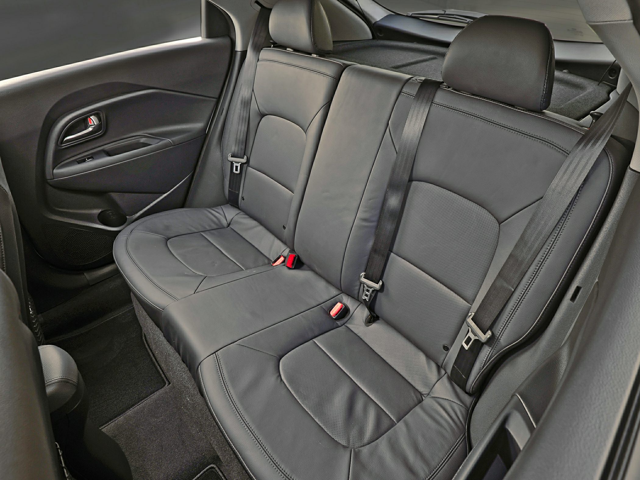 Black leather rear seats with seat belts and door panel in compact hatchback