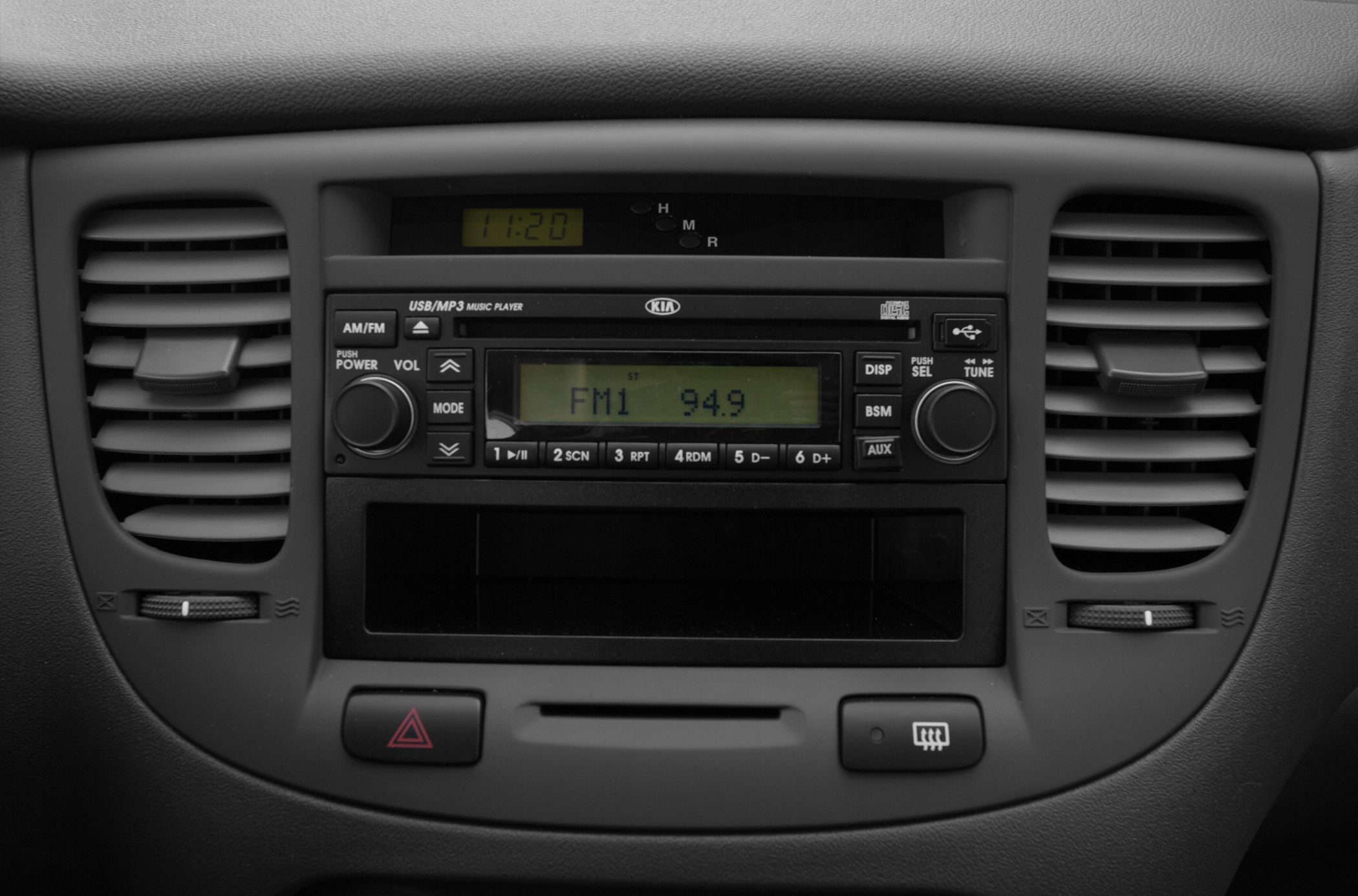 Car radio and air vents with control knobs and digital clock