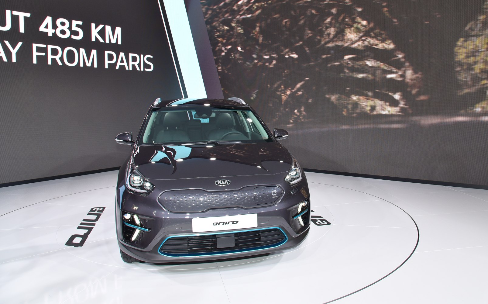 Electric vehicle front view with closed grille and LED headlights.