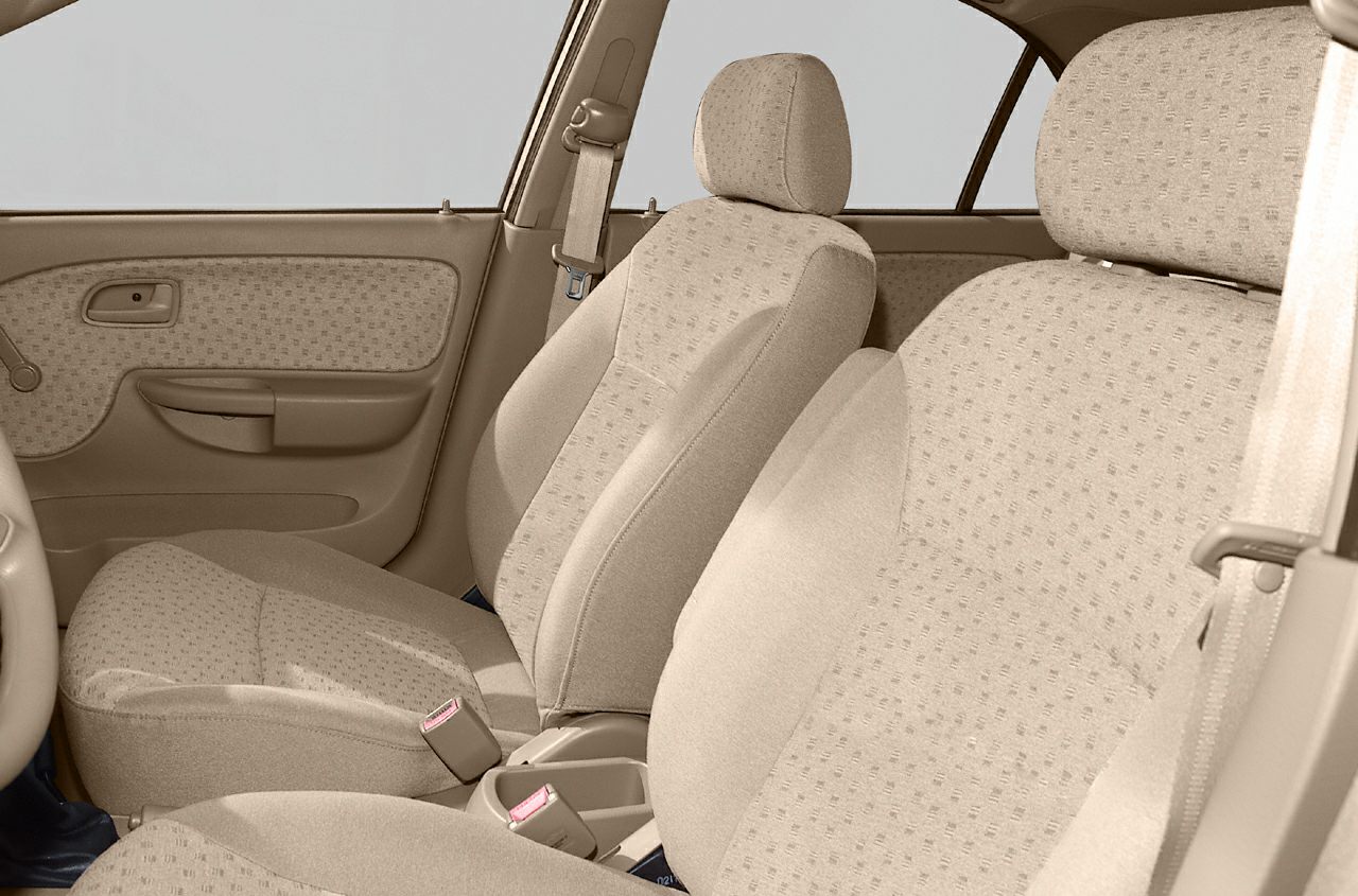 Beige fabric front seats and door panel with seatbelt in car interior