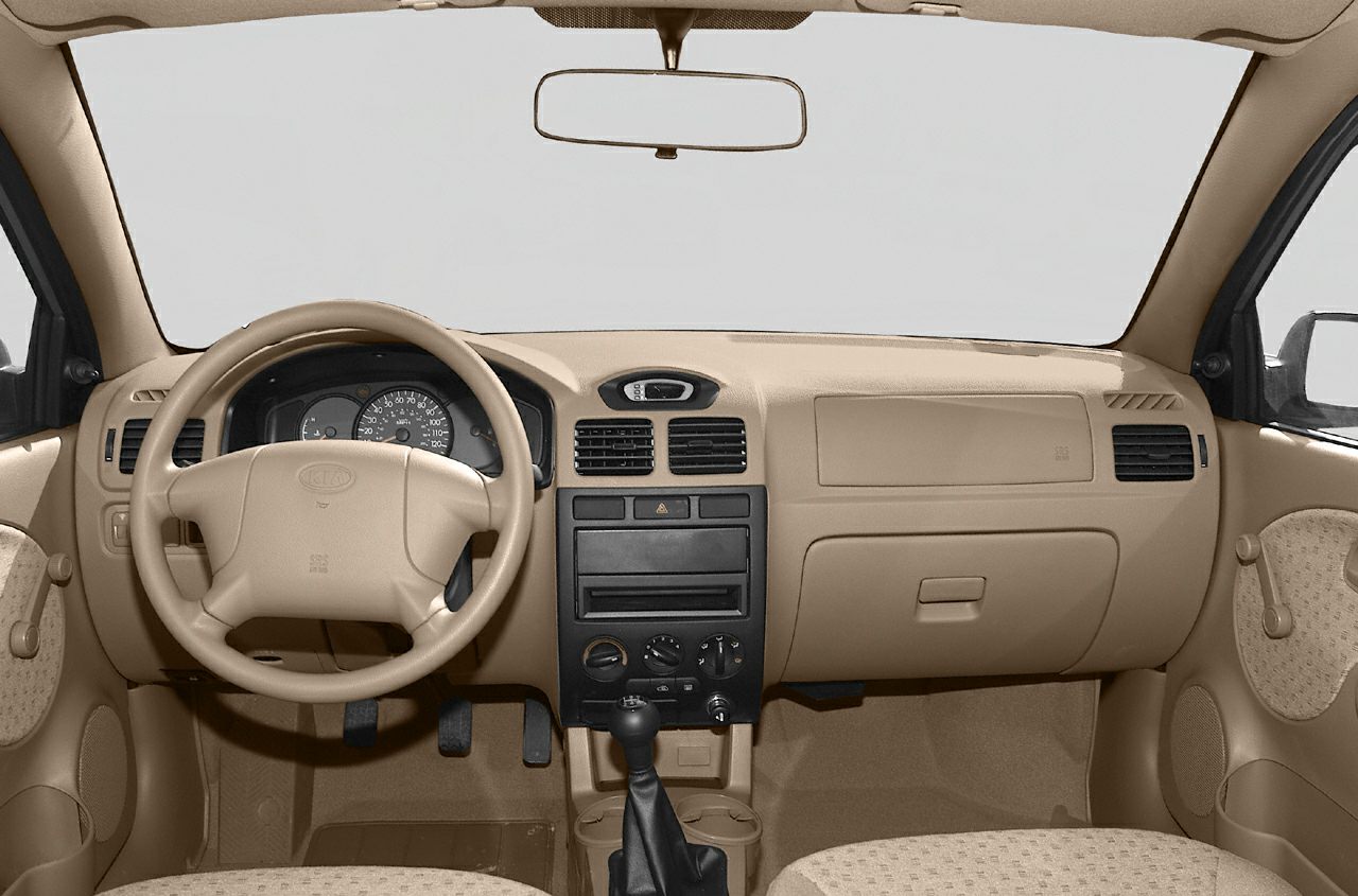 Beige dashboard with steering wheel, instrument cluster, and manual gear stick