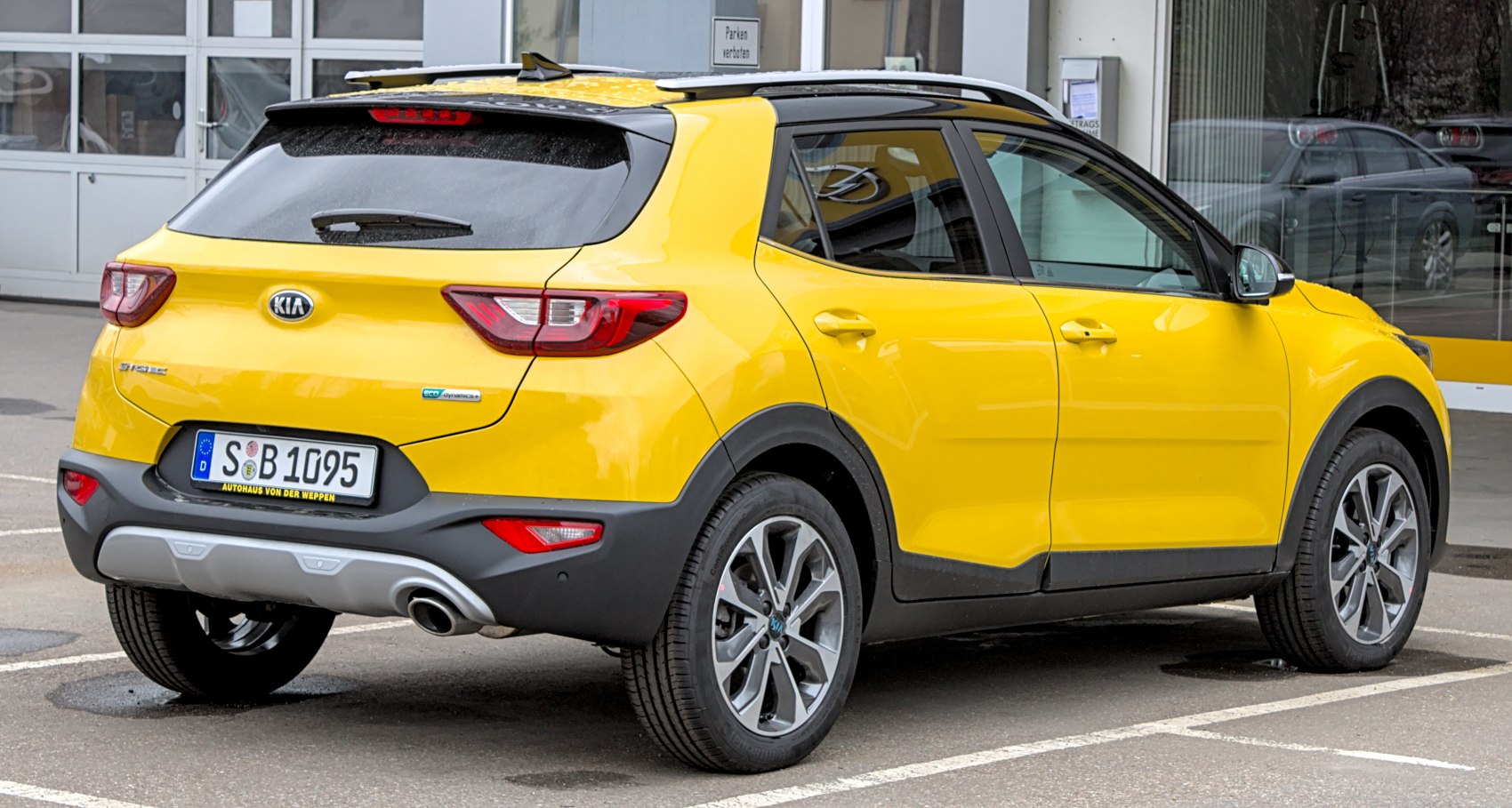 Rear and side view of bright yellow compact crossover with sporty wheels and roof rails