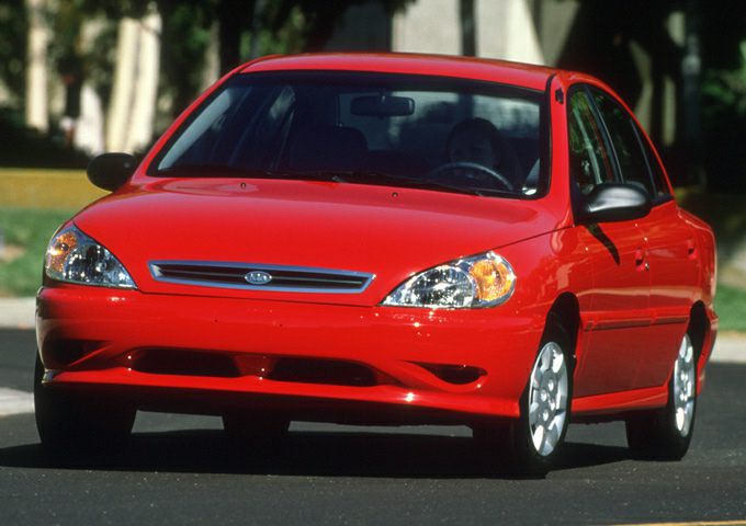 Front view of red compact sedan with distinct headlights and grille.