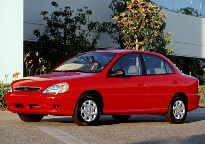 Red compact sedan with front side view, aerodynamic shape and classic design.
