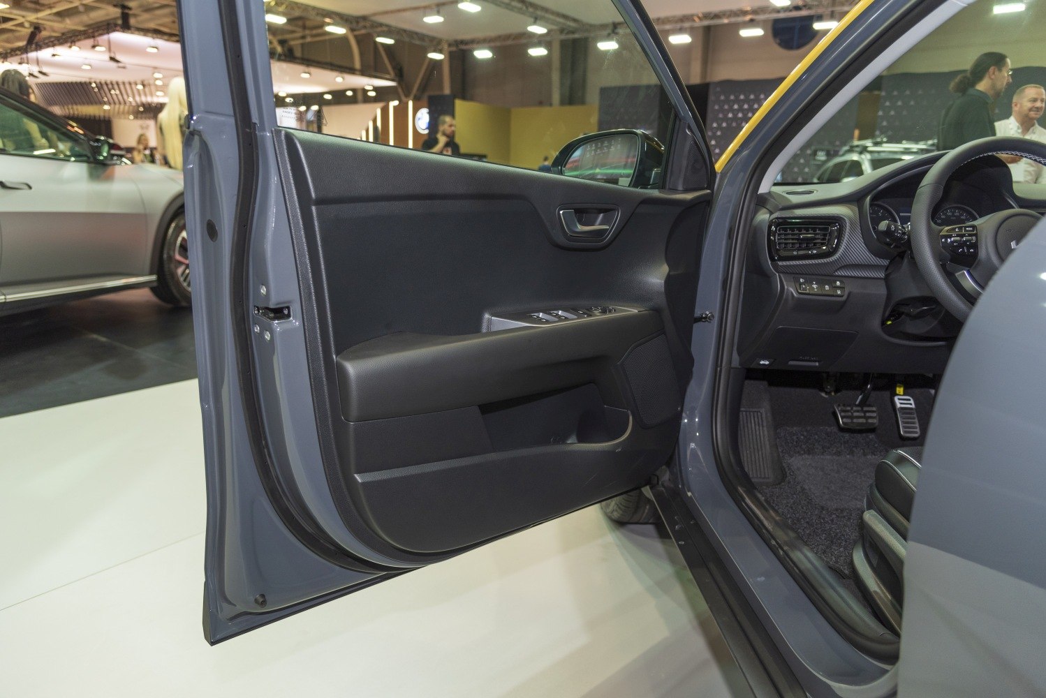 Driver door panel with controls and dashboard interior of a vehicle