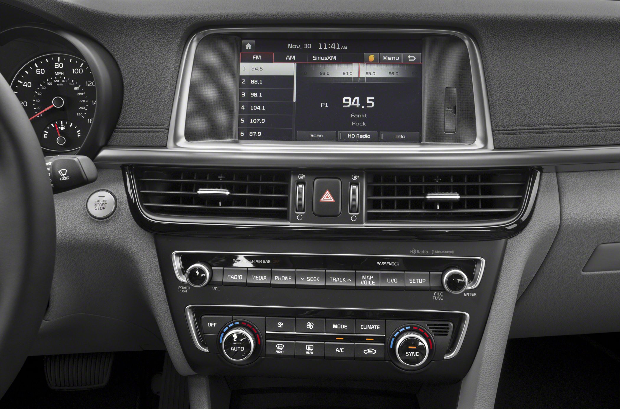 Car dashboard and infotainment system with climate control knobs.