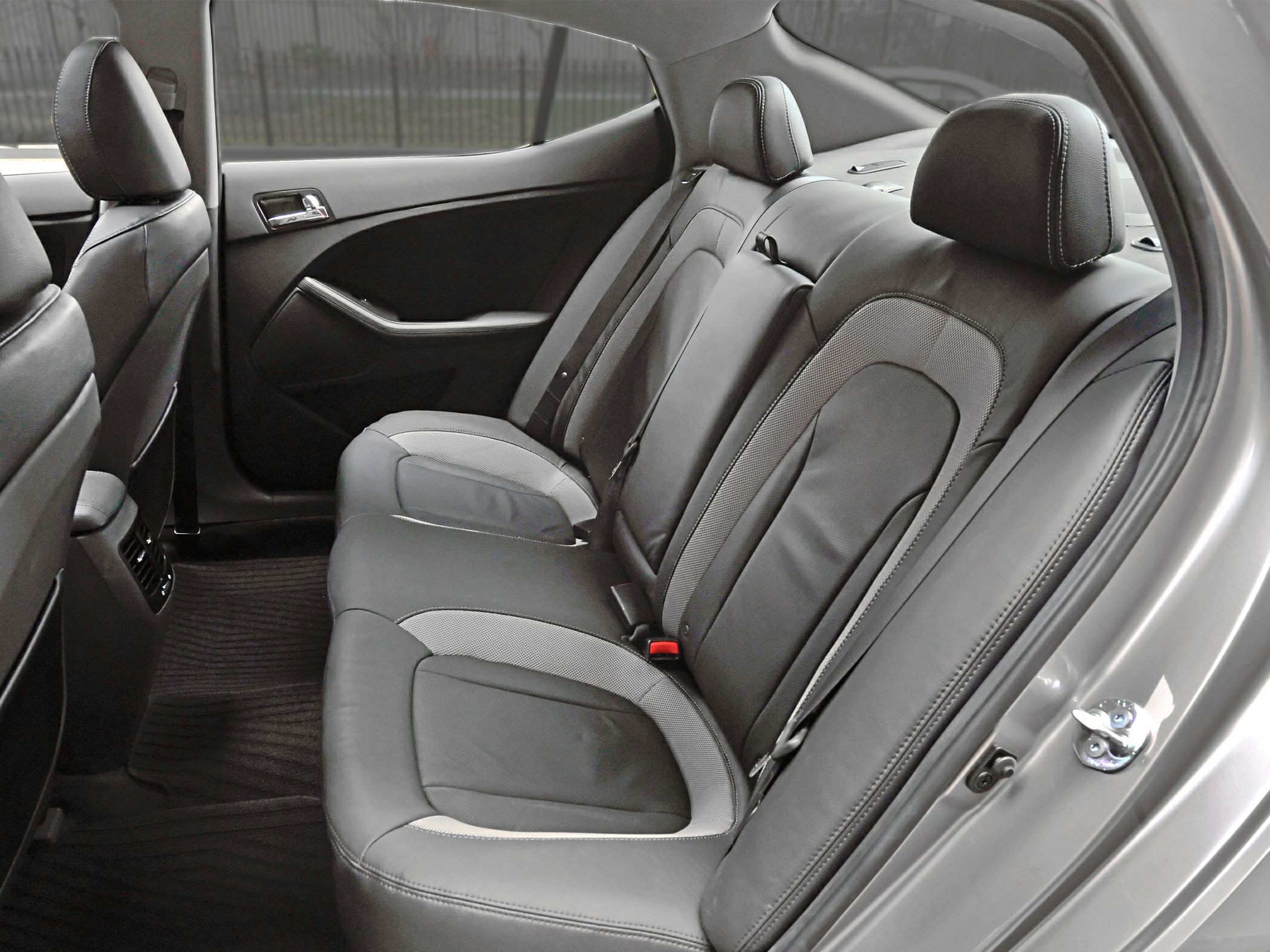 Rear leather seat upholstery with headrests and door panel in a sedan