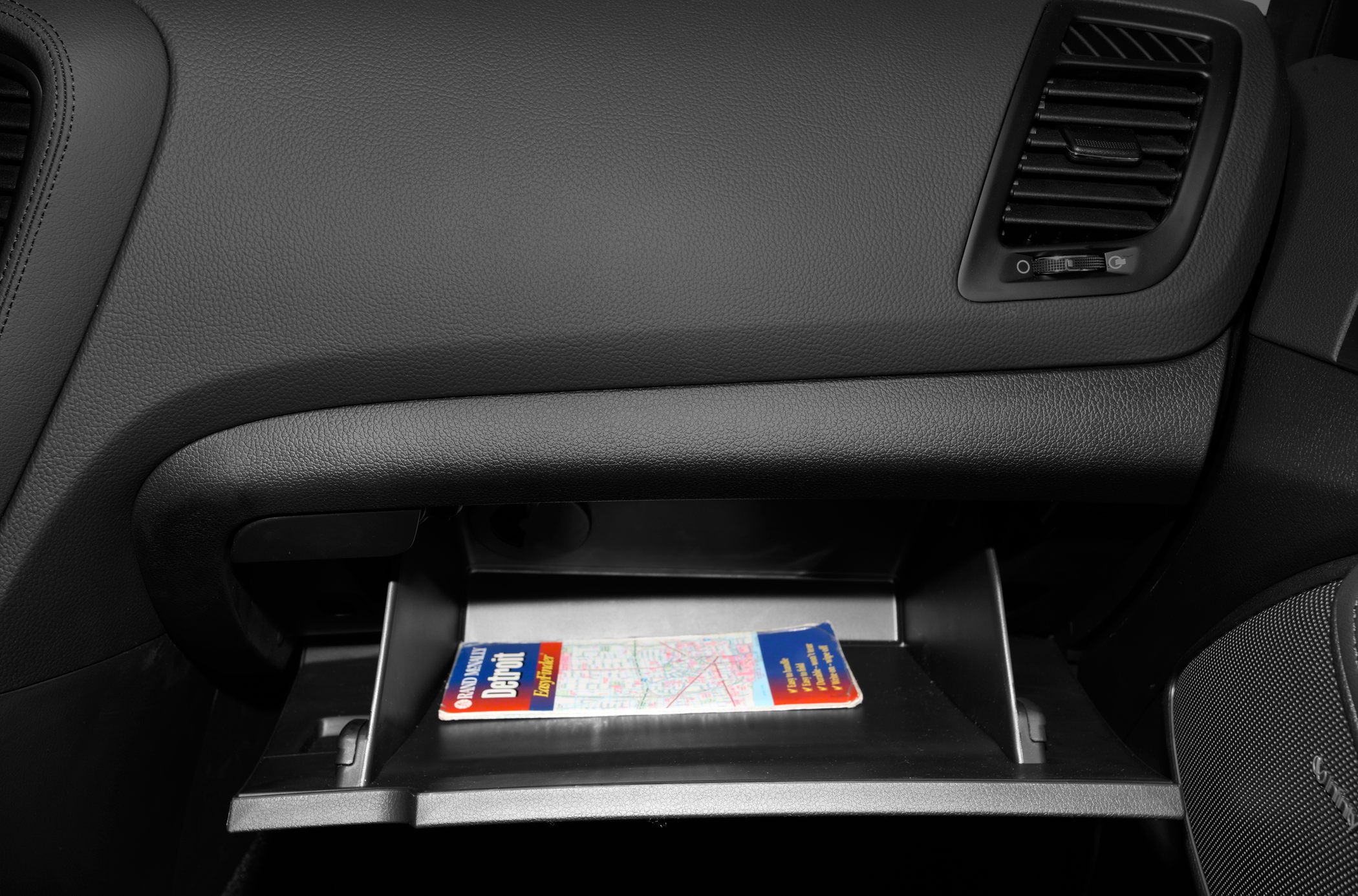 Open glove compartment with map inside, car interior storage