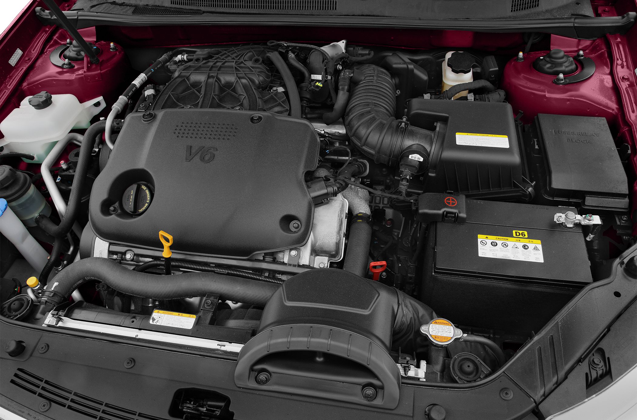 V6 engine bay with components and battery in sedan