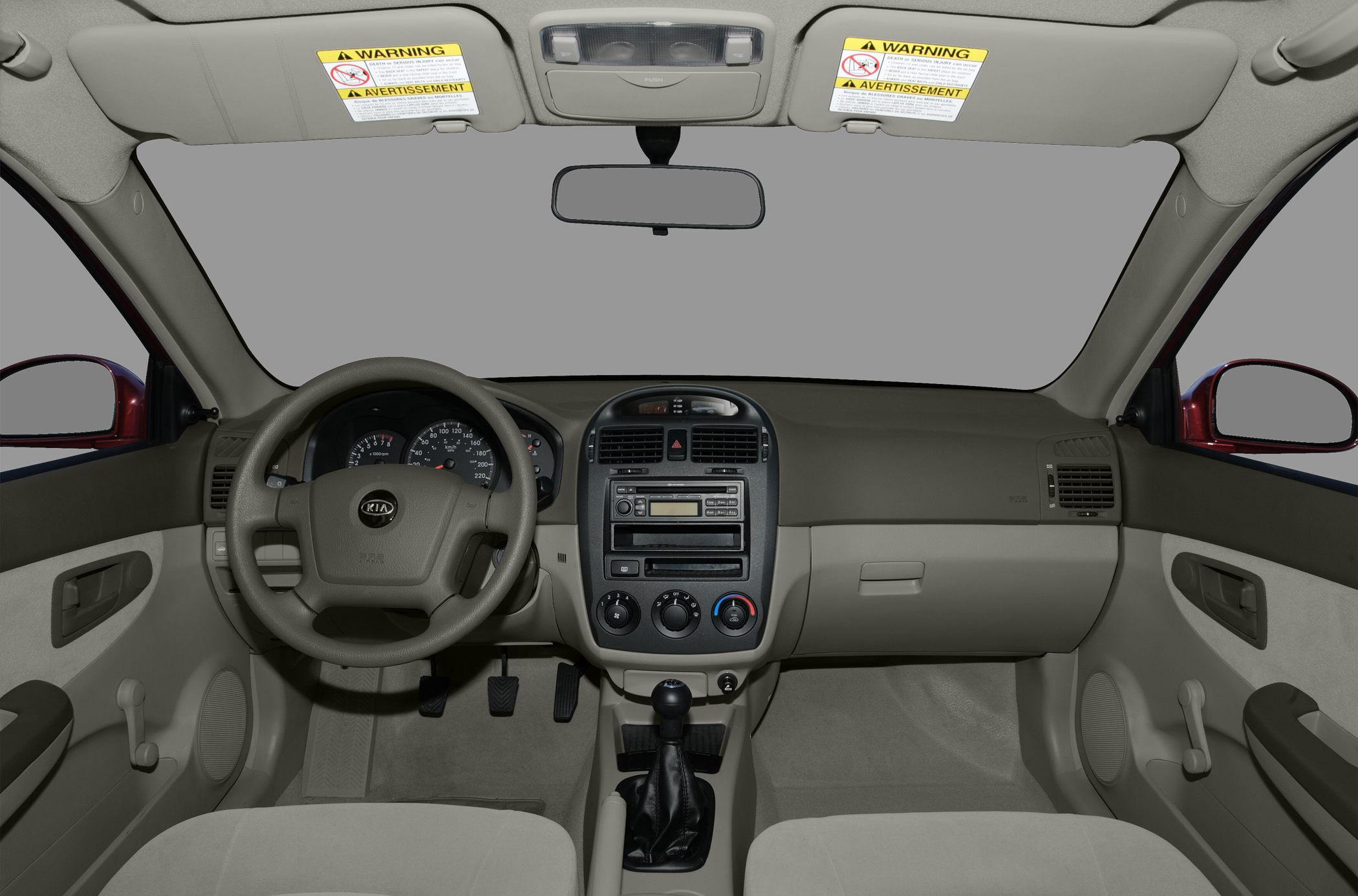 Car interior dashboard with manual gear shift and steering wheel.