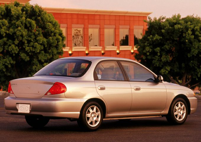 Rear side view of a silver four-door sedan with rounded tail lights and alloy wheels.