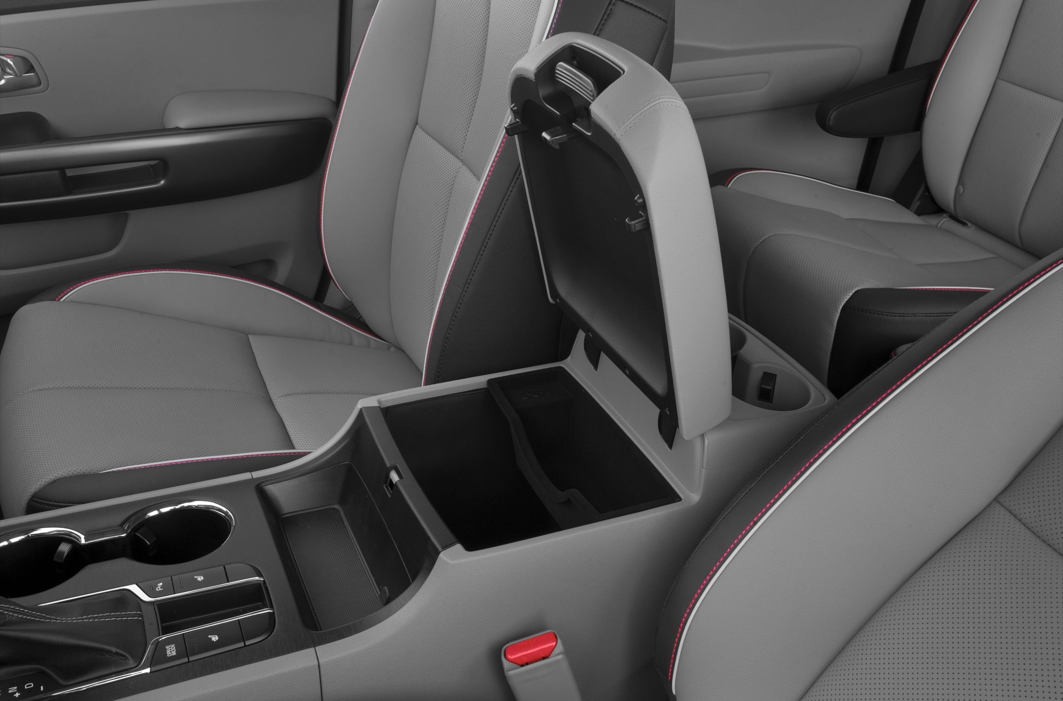 Gray leather seats with red stitching and open center console storage