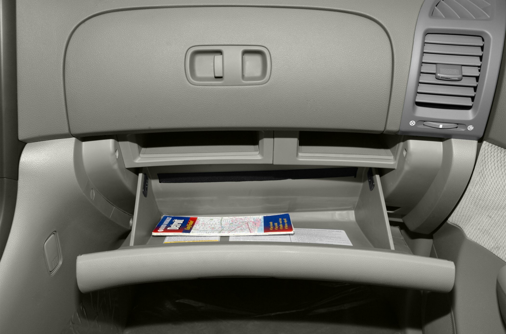 Open glove compartment and dashboard vent in car interior