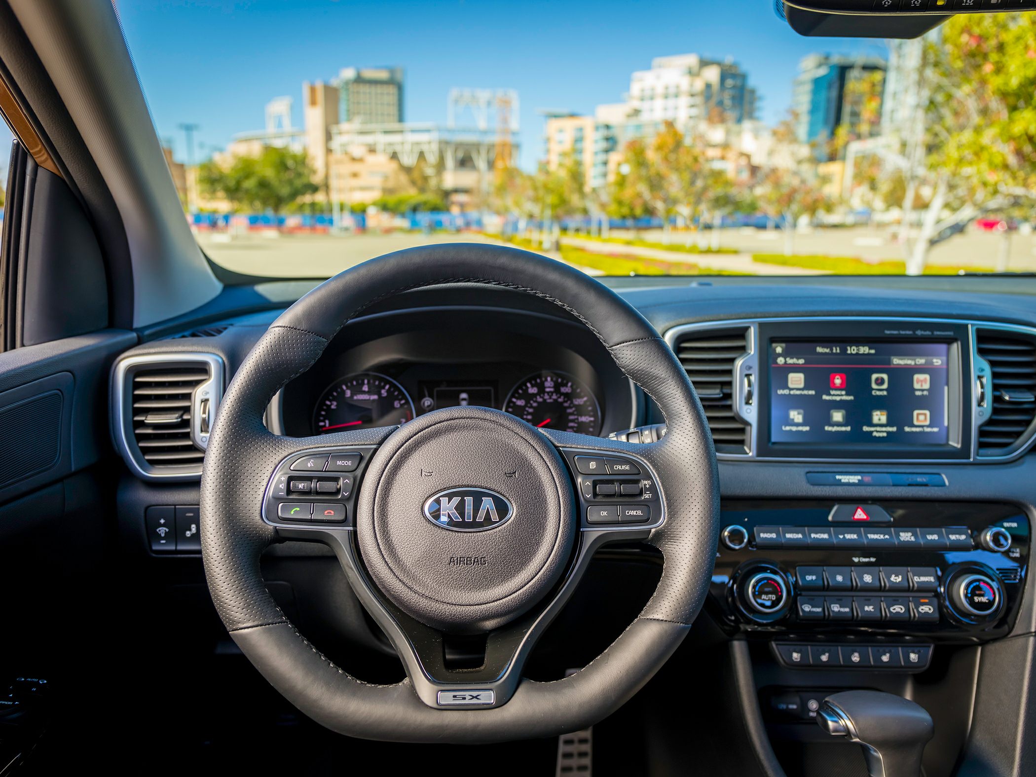 Steering wheel with control buttons and dashboard infotainment display.
