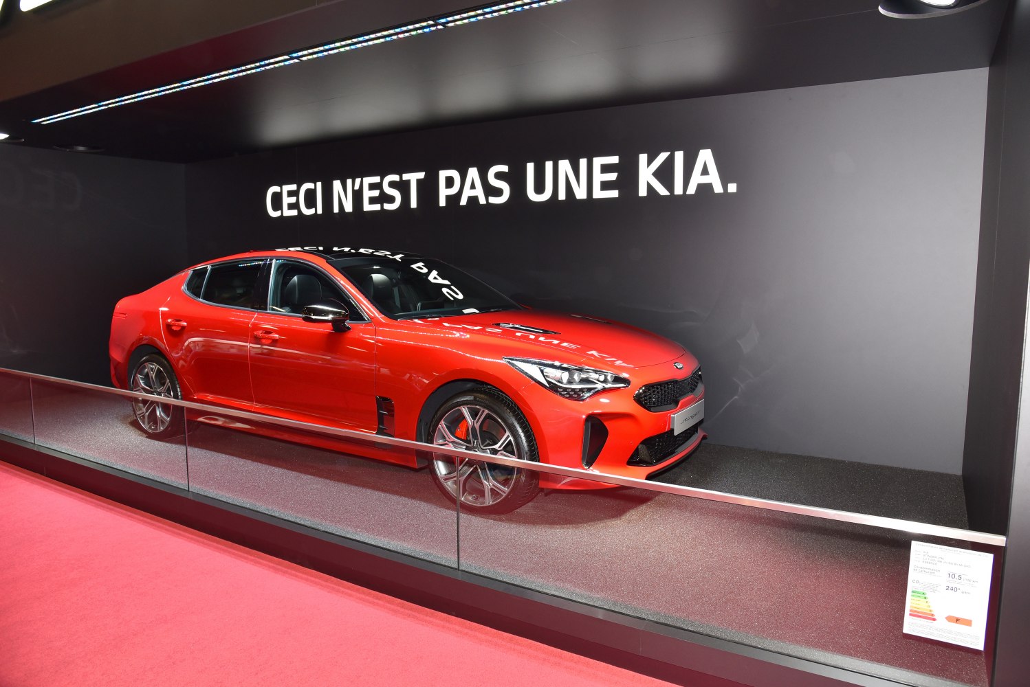 Red sports sedan with sharp headlights and aerodynamic front grille