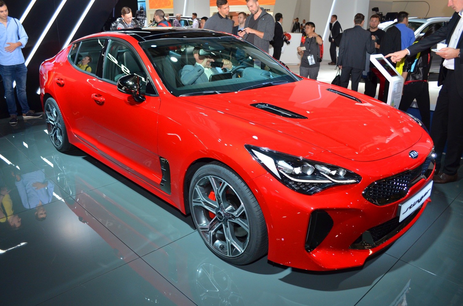 Red sports sedan with black roof and alloy wheels