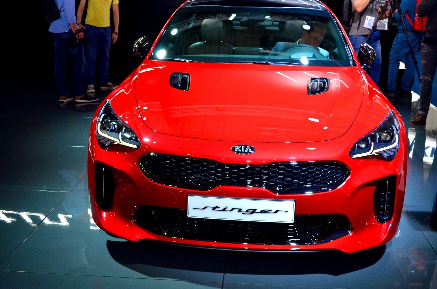 Red Kia Stinger front view with sporty headlights and honeycomb grille