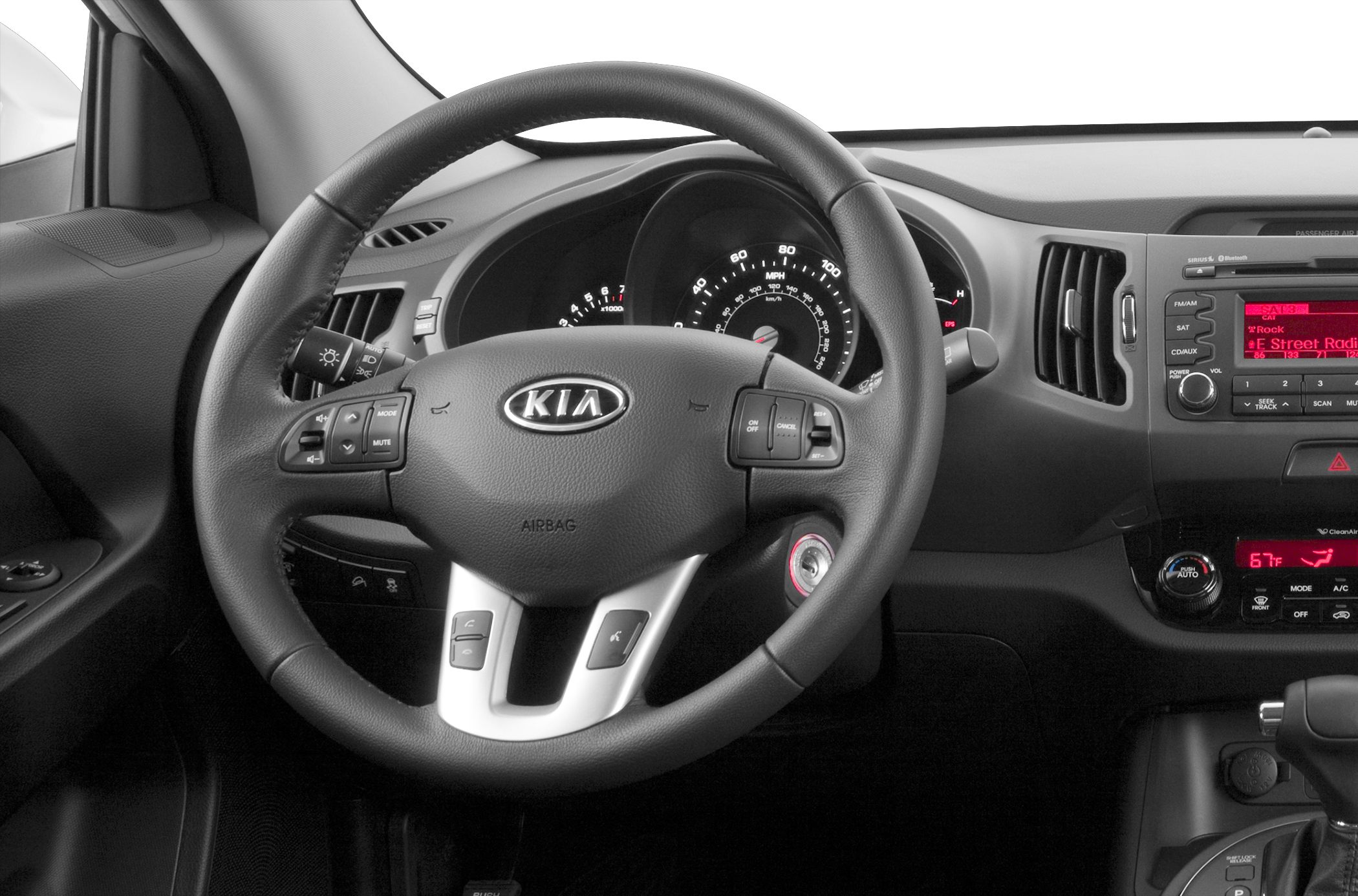 Steering wheel with control buttons and dashboard with instrument cluster and media console