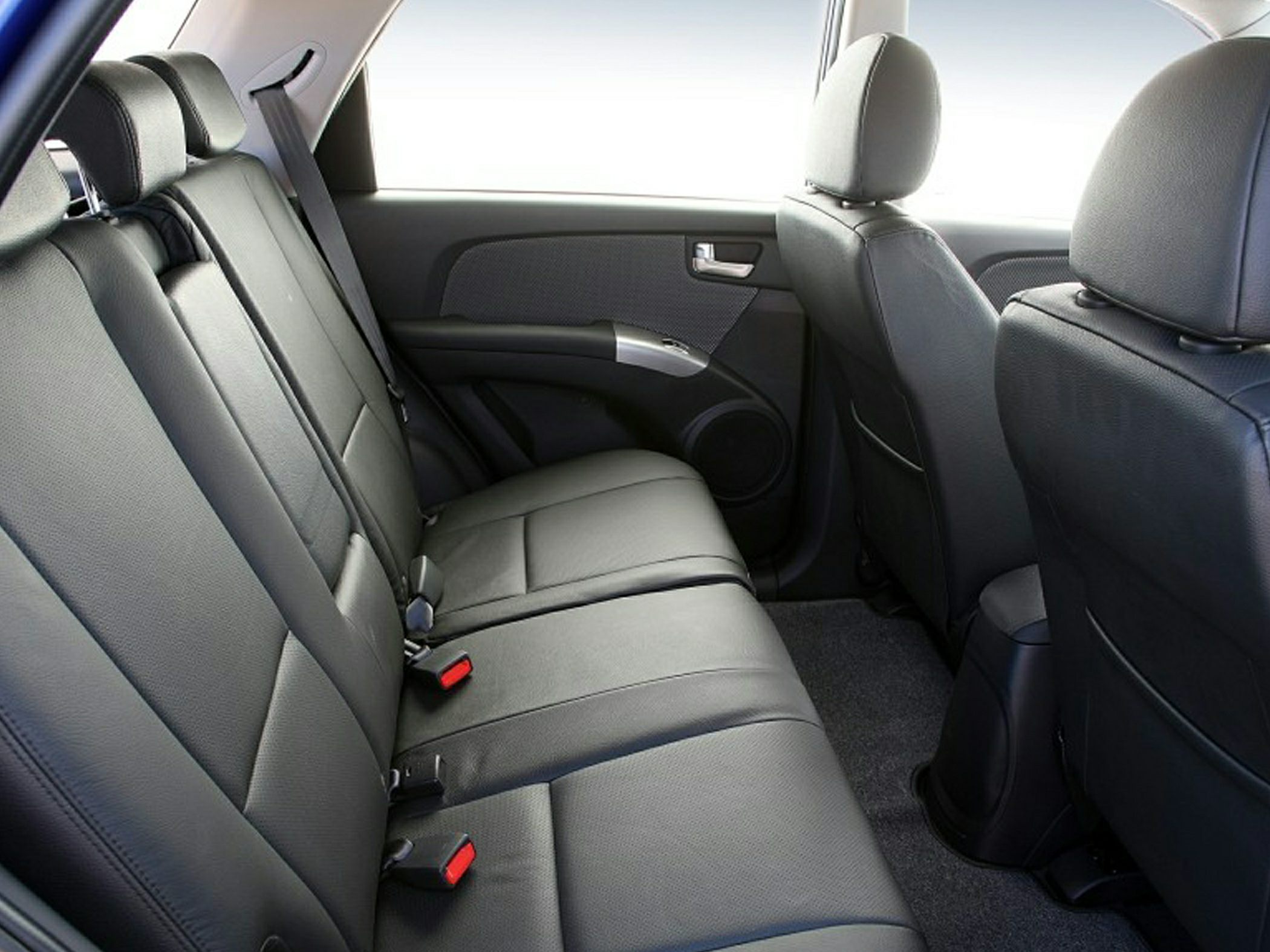 Spacious rear seats with black leather upholstery and seat belts inside vehicle