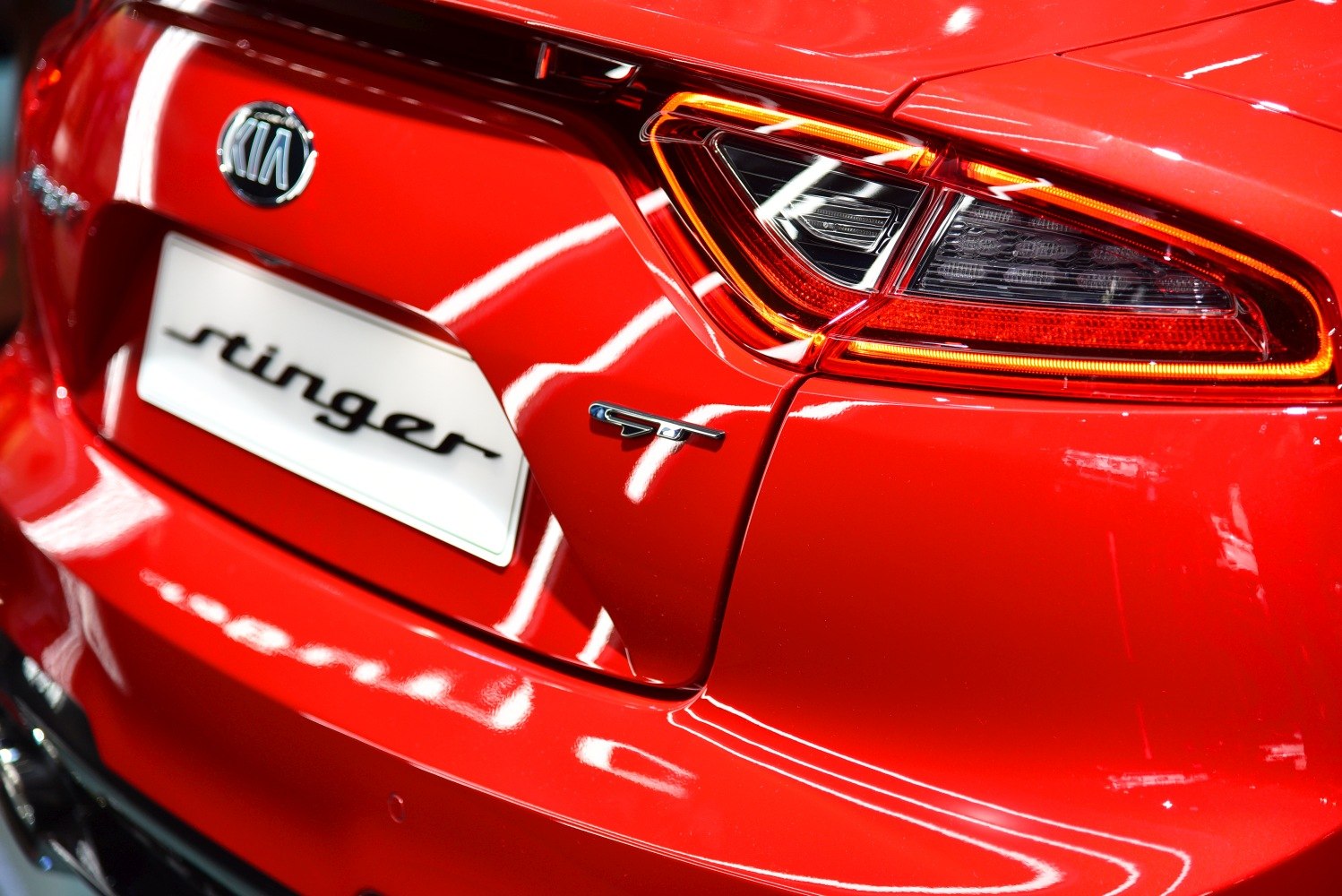 Rear LED tail light and GT badge on a red sporty sedan