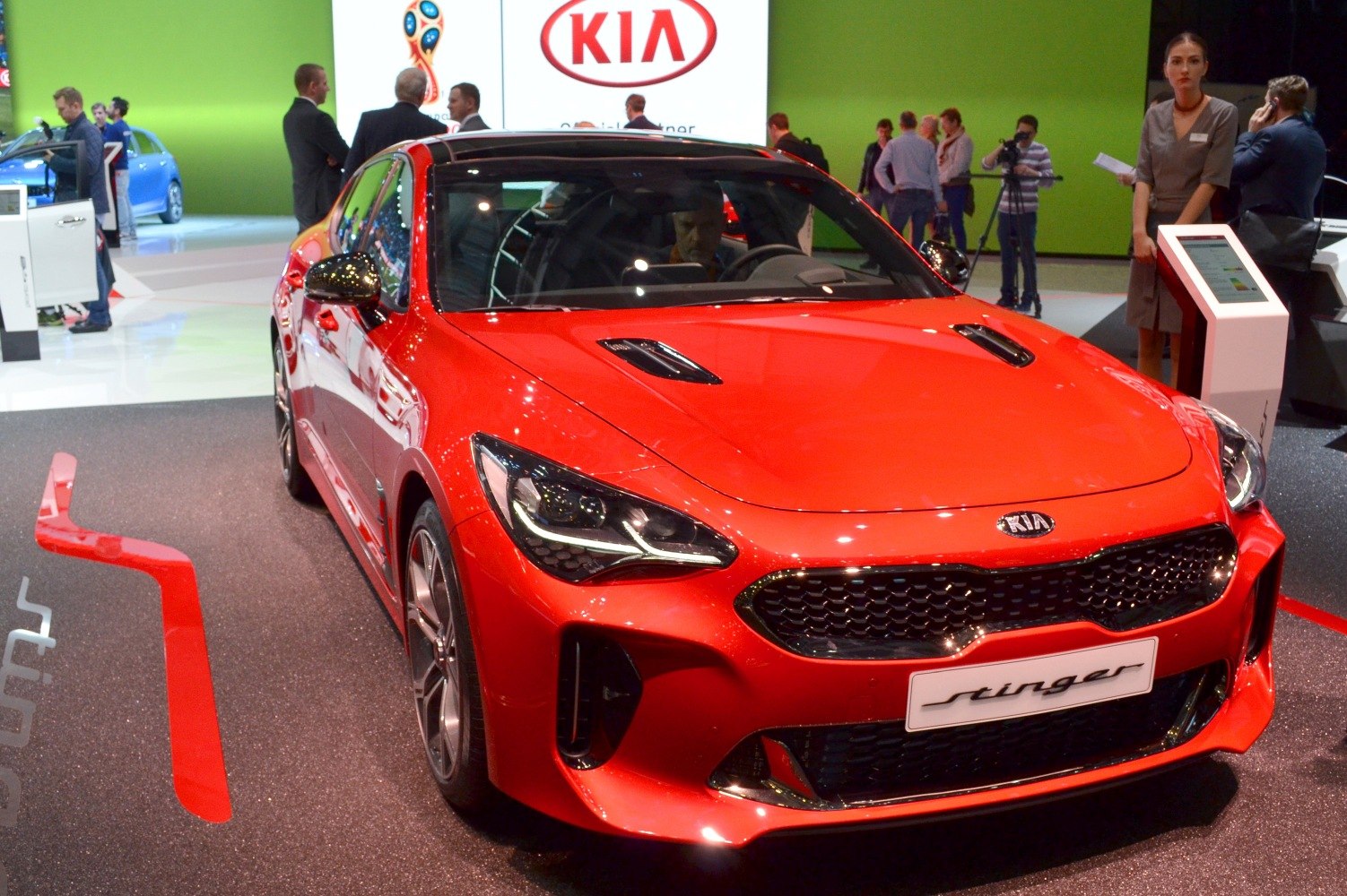 Red car front with aggressive headlights and vented hood